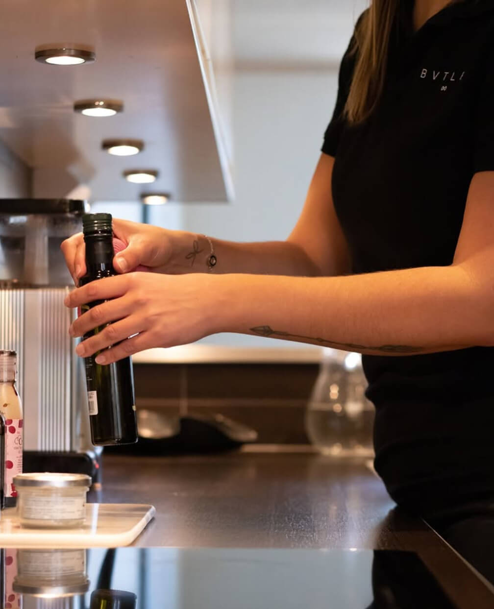 bvtlermedarbetare ställer en svart flaska på sin plats i köket