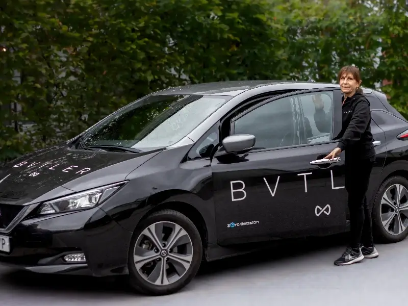 bvtler-medarbetare som öppnar dörren till en svart bvtler-bil.