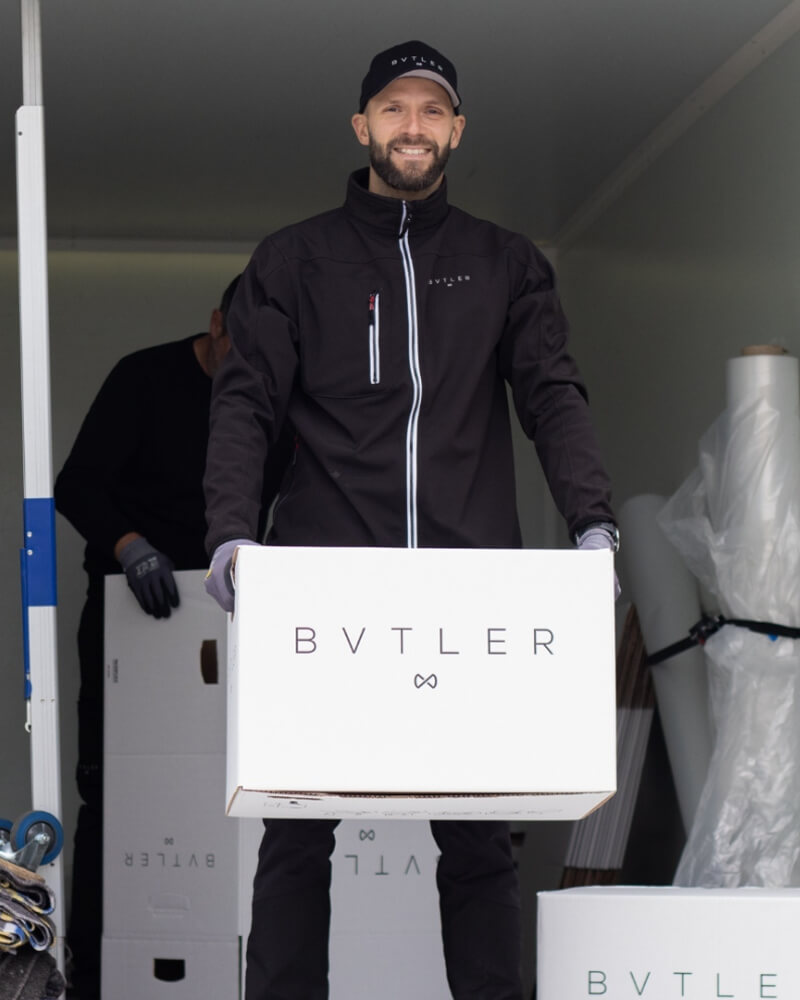 bvtler-medarbetare som bär en flyttlåda under ett flyttuppdrag.